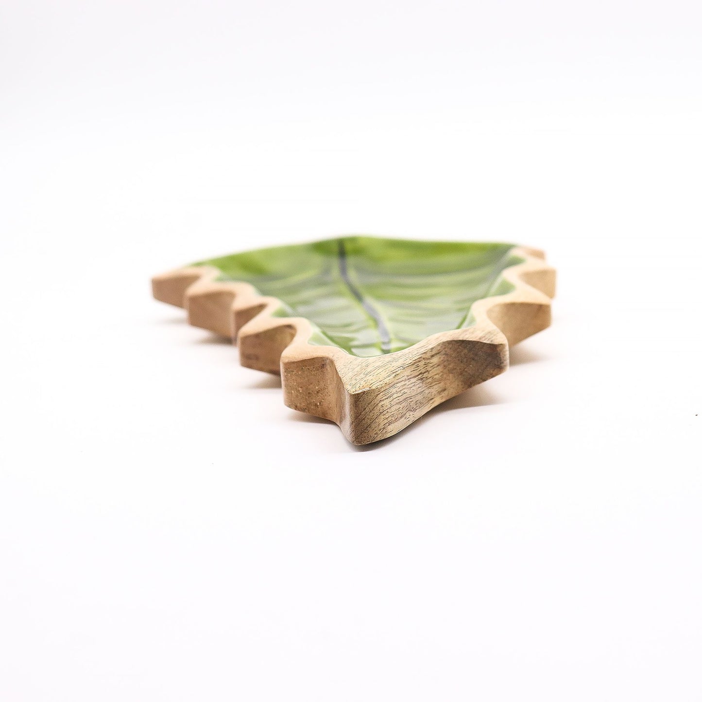 Large leaf-shaped mango wood bowl with rich green enamel inside, filled with pine cones and candles on autumn table setting