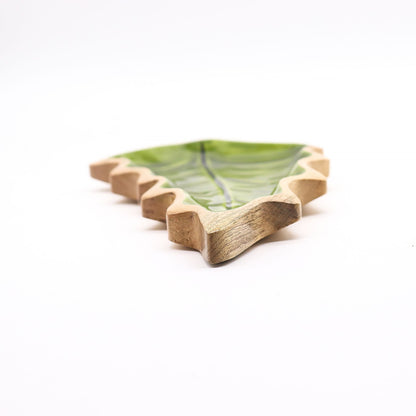 Large leaf-shaped mango wood bowl with rich green enamel inside, filled with pine cones and candles on autumn table setting