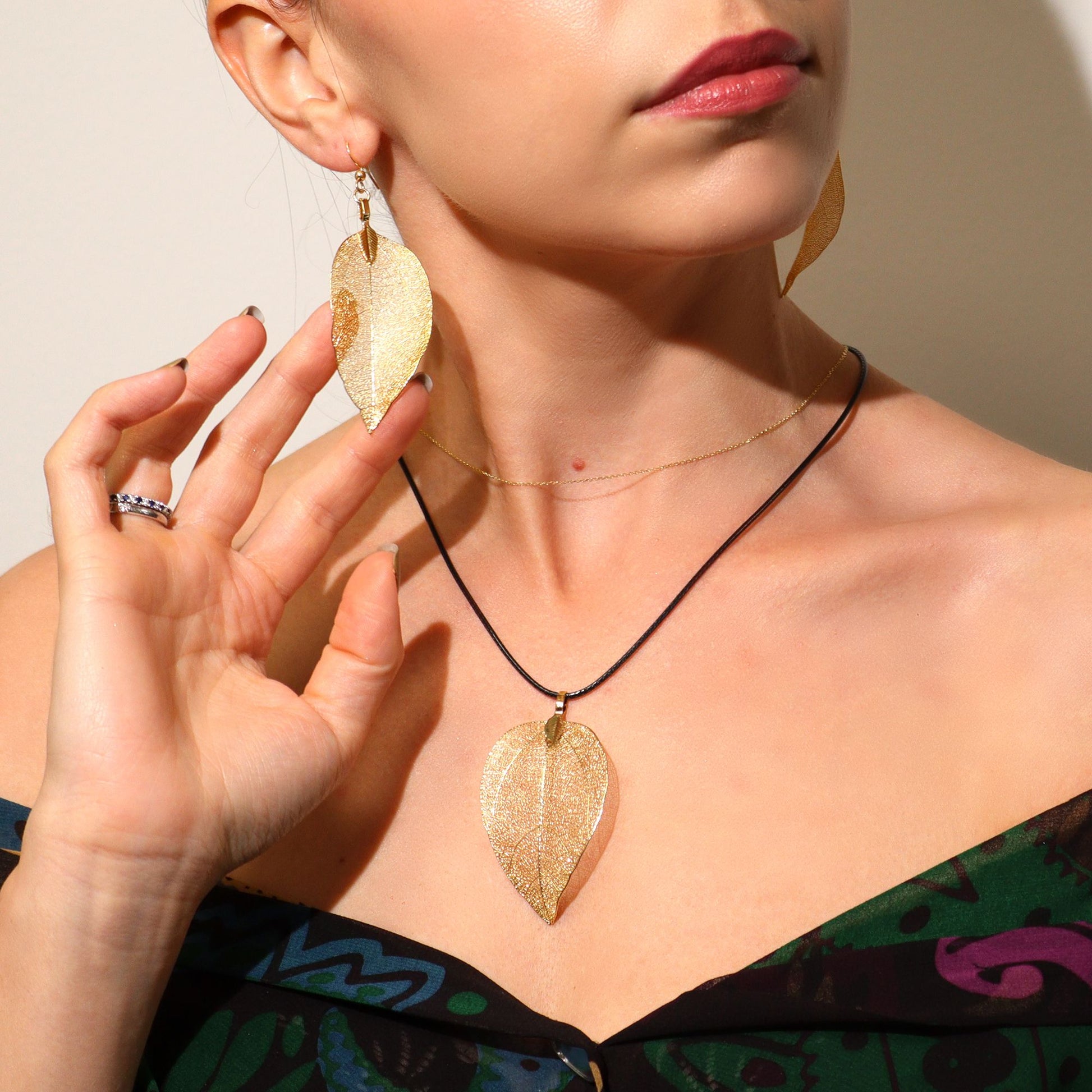 Woman wearing gold leaf earrings and necklace