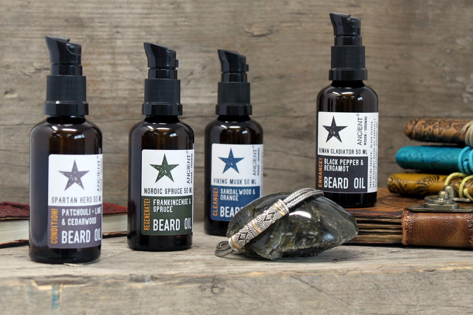Five bottles of beard oil with labels on a wooden surface.