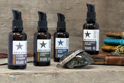 Five bottles of beard oil with labels on a wooden surface.