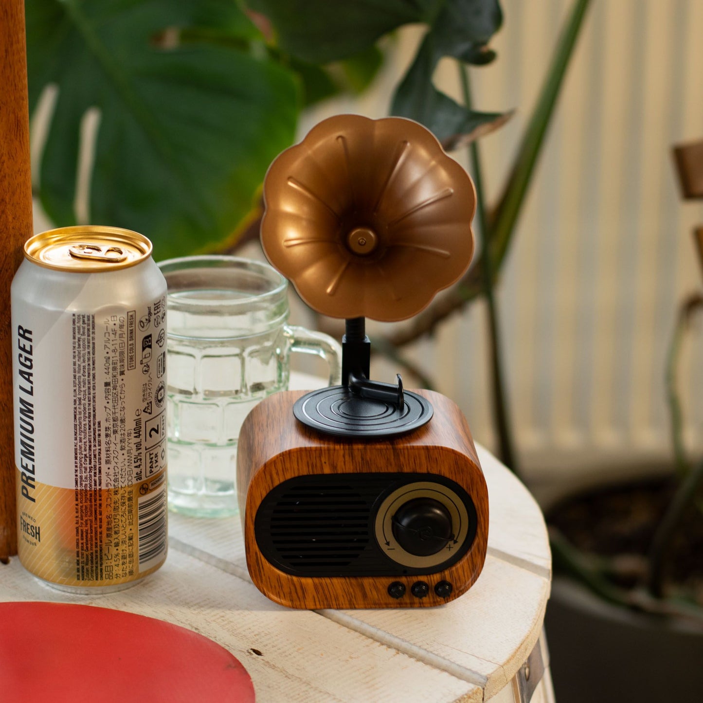 Retro mini gramophone Bluetooth speaker in classic horn shape with warm wood-effect base, playing music on wooden desk