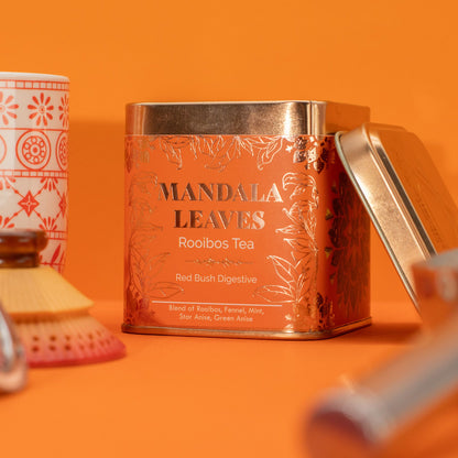 50g tin of Red Bush Digestive rooibos tea with warm orange & gold label, loose leaves with fennel seeds, mint leaves and anise stars