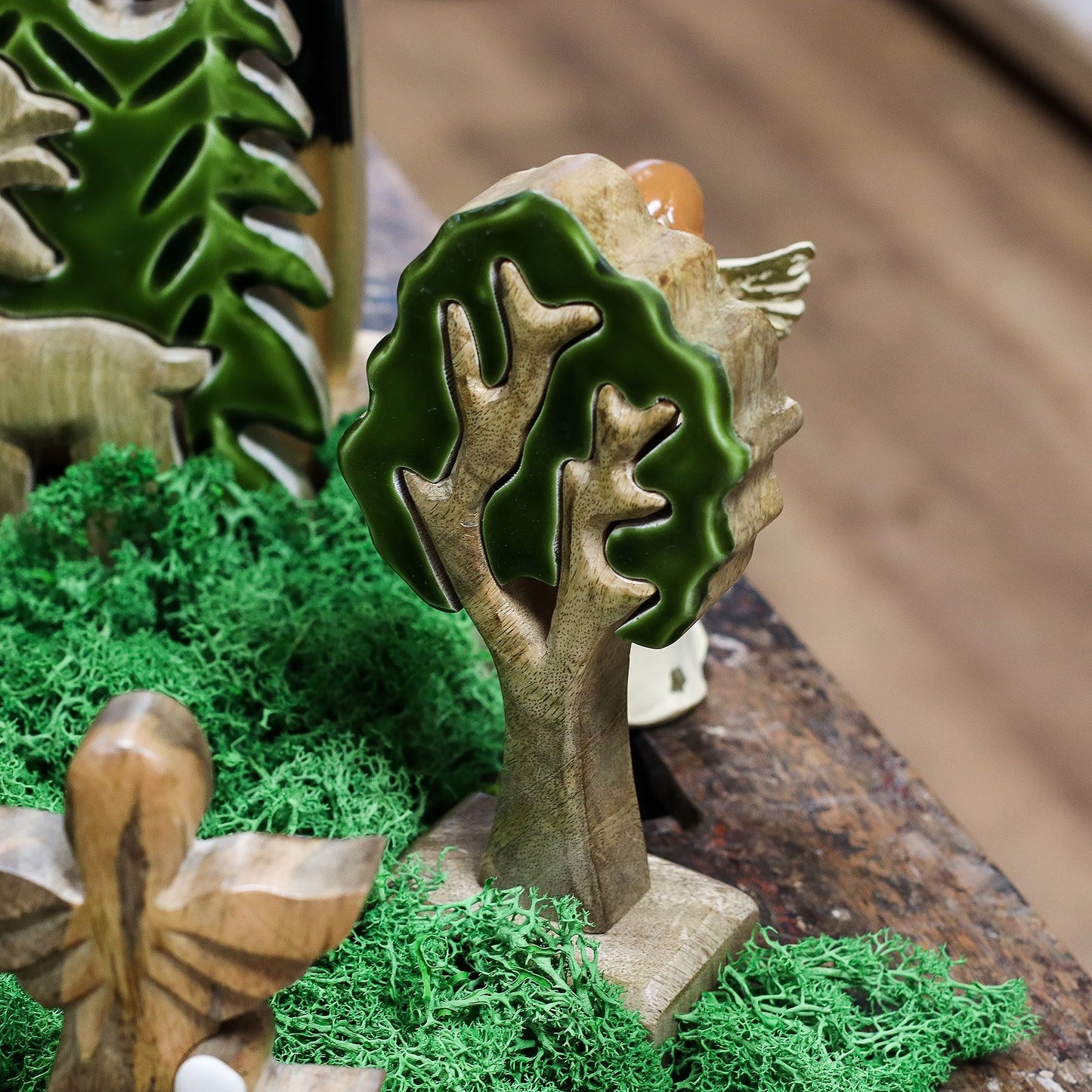 20 cm tall 3D mango wood Christmas tree with deep green enamel branches on wooden base, styled on shelf with fairy lights and pine cones