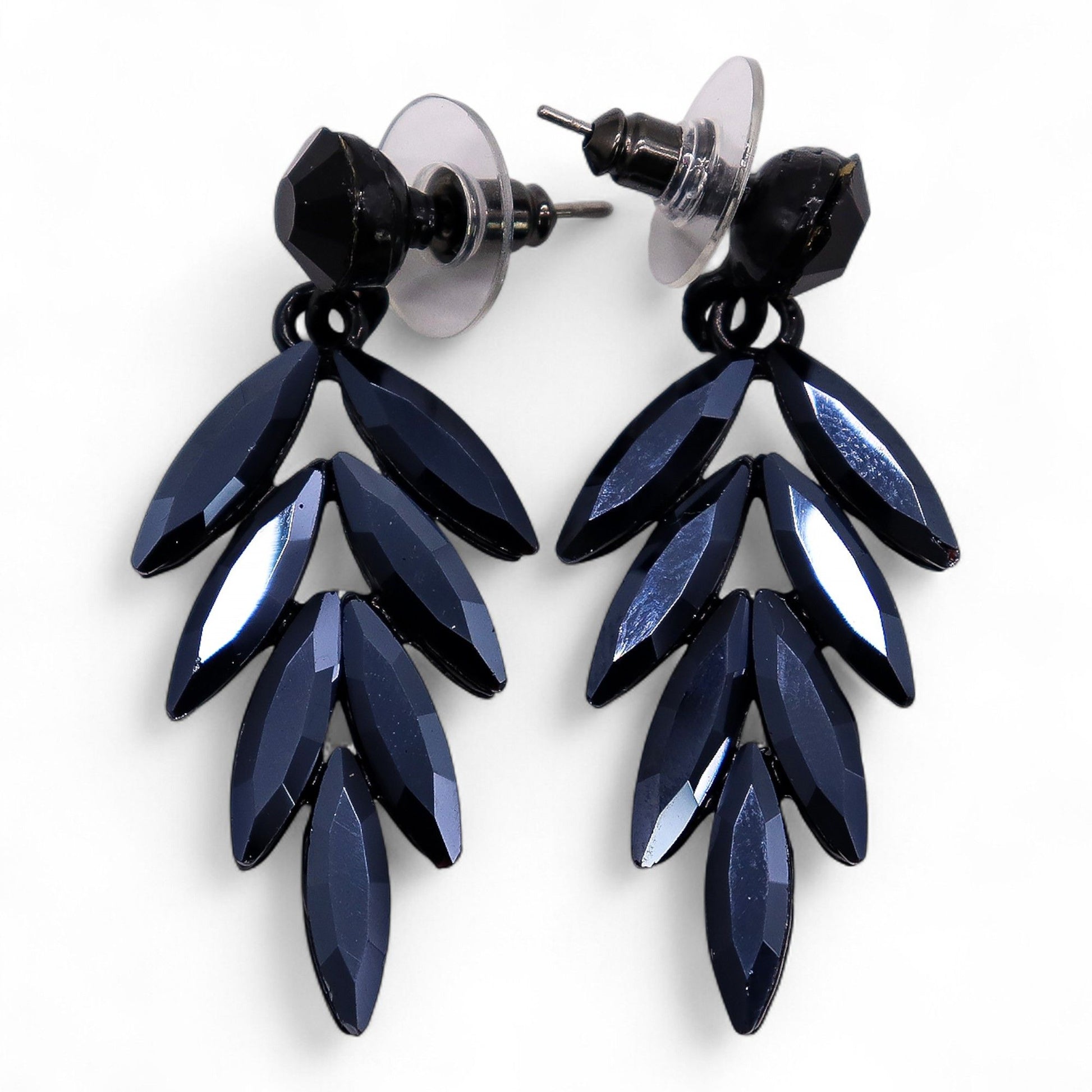 Jet black vintage glass long drop earrings catching firelight, styled against black velvet with glowing embers and obsidian stones