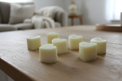 Nutmeg & Lemon Aroma Wax Melts with heart-shaped soy wax pieces on a wooden surface with soft, warm light