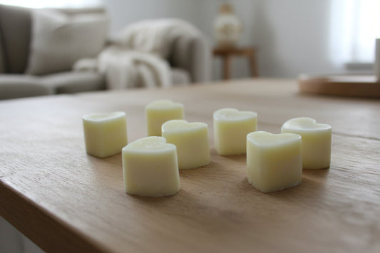 Nutmeg & Lemon Aroma Wax Melts with heart-shaped soy wax pieces on a wooden surface with soft, warm light