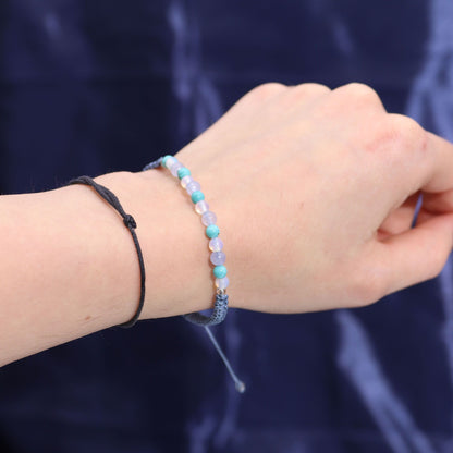 Close-up of a hand wearing two beaded bracelets