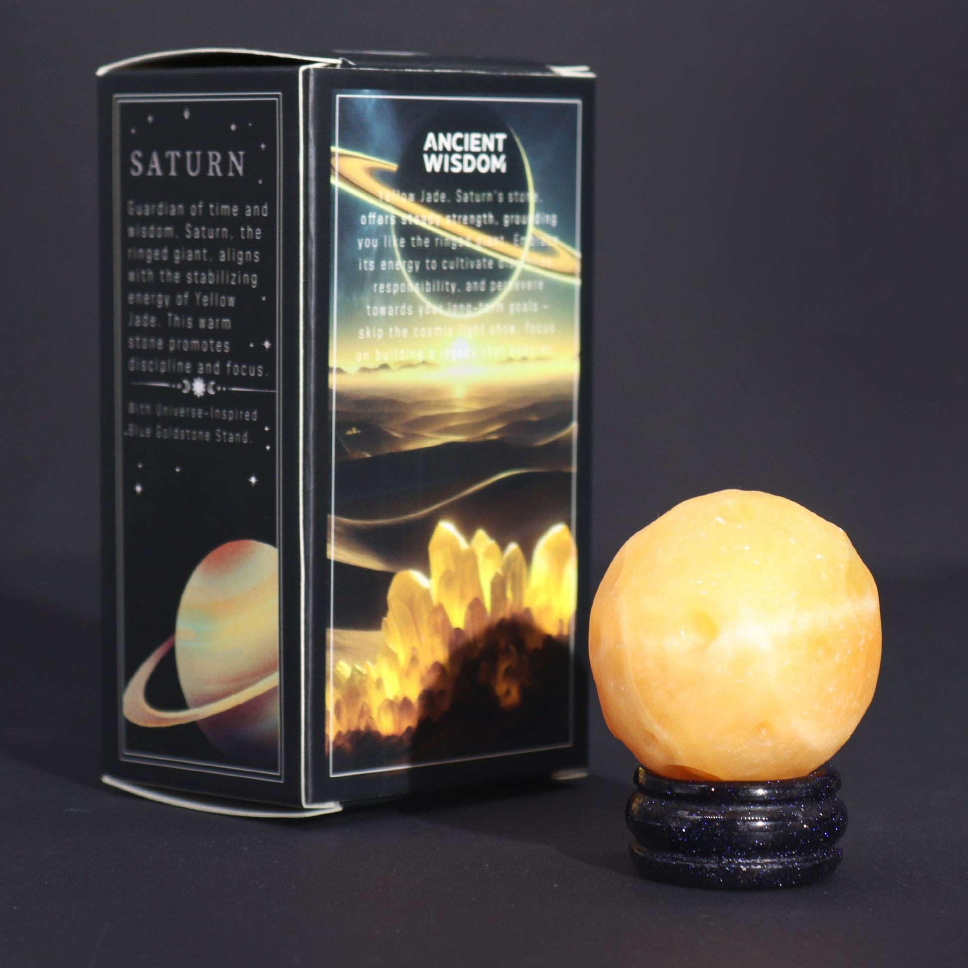 40mm yellow jade Saturn sphere floating on shimmering goldstone ring stand, glowing against starry black background with subtle cosmic light