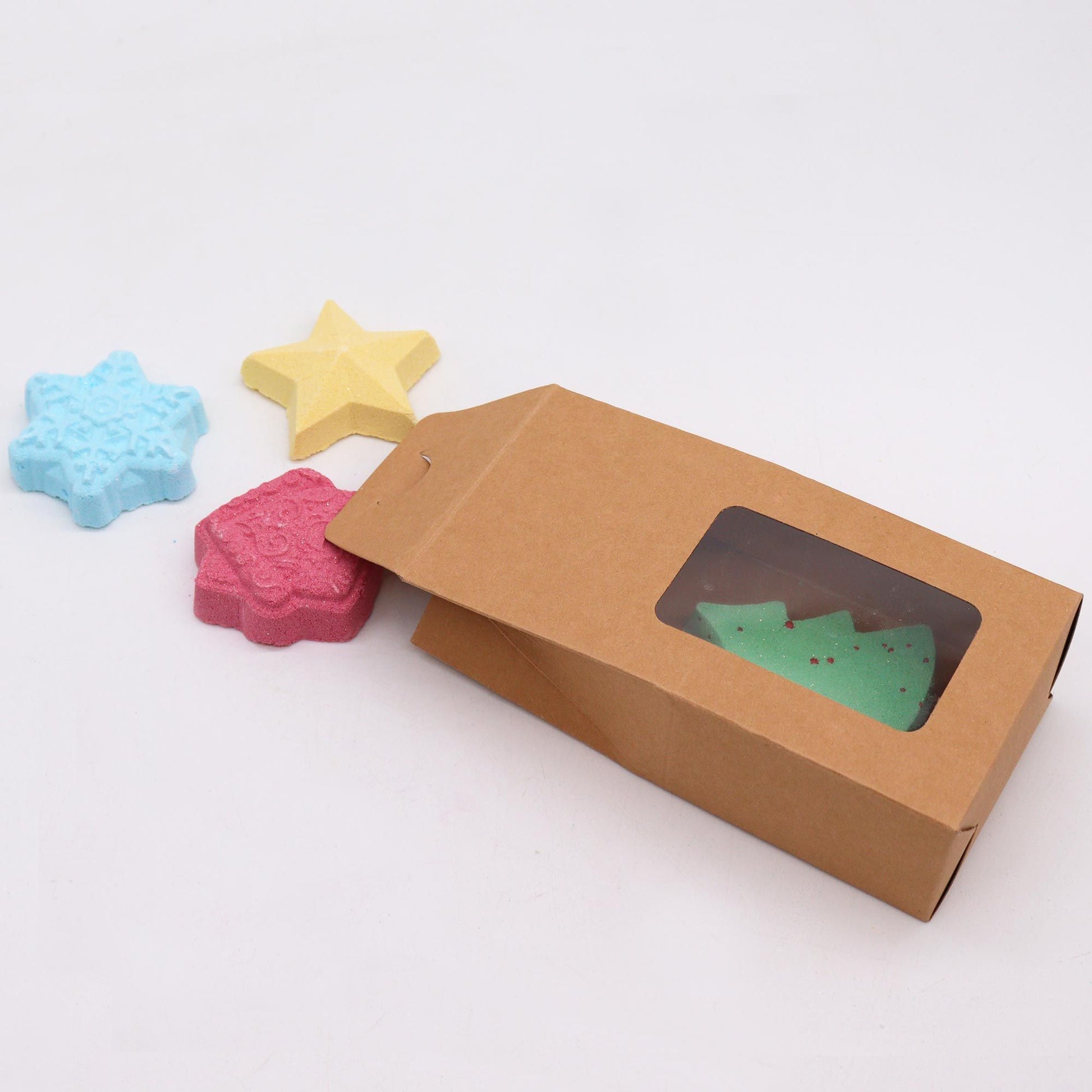 Christmas Wish List bath bomb gift pack with snowflake, gold star, green tree and gingerbread house bombs in elegant kraft box with gold ribbon