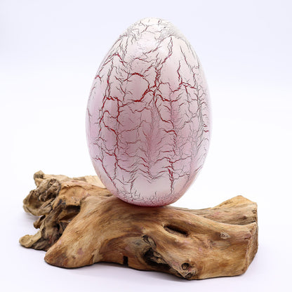 Vivid orange crackle egg shade glowing like molten fire atop twisted driftwood base