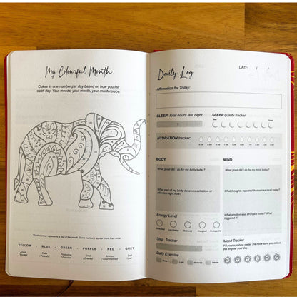 Open journal with coloring page of an elephant and daily log on a wooden surface