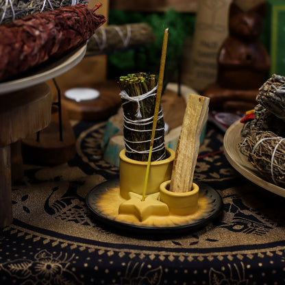 Speckled sand & grey ceramic mandala smudge holder with Palo Santo stick burning, sage bundle and incense cone, styled on neutral linen altar