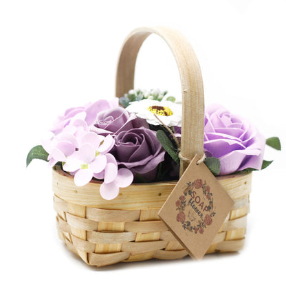 Medium lilac soap flower bouquet with lifelike roses and blooms beautifully arranged in natural wicker basket, tied with ribbon, presented as luxury bath gift on soft white background