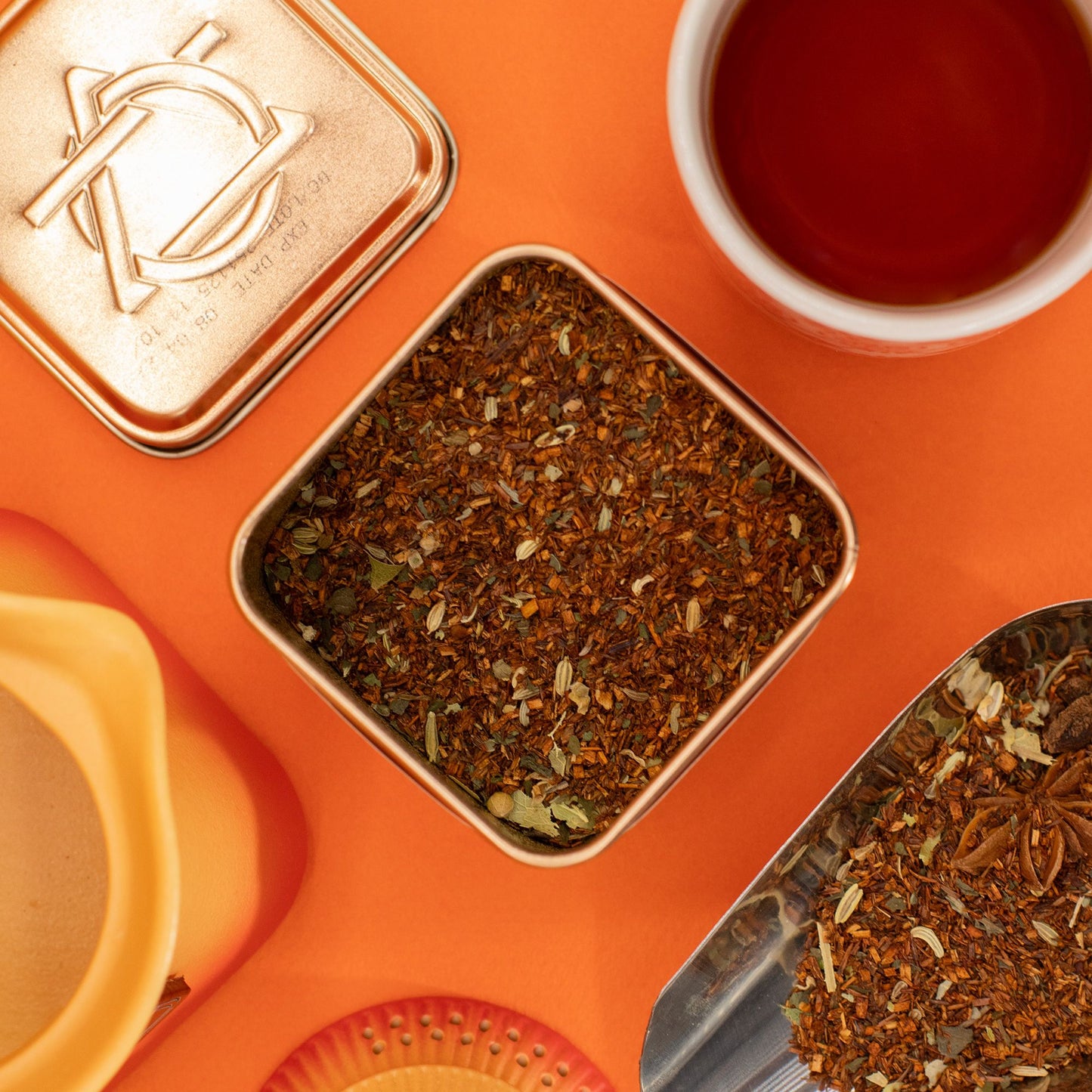 50g tin of Red Bush Digestive rooibos tea with warm orange & gold label, loose leaves with fennel seeds, mint leaves and anise stars