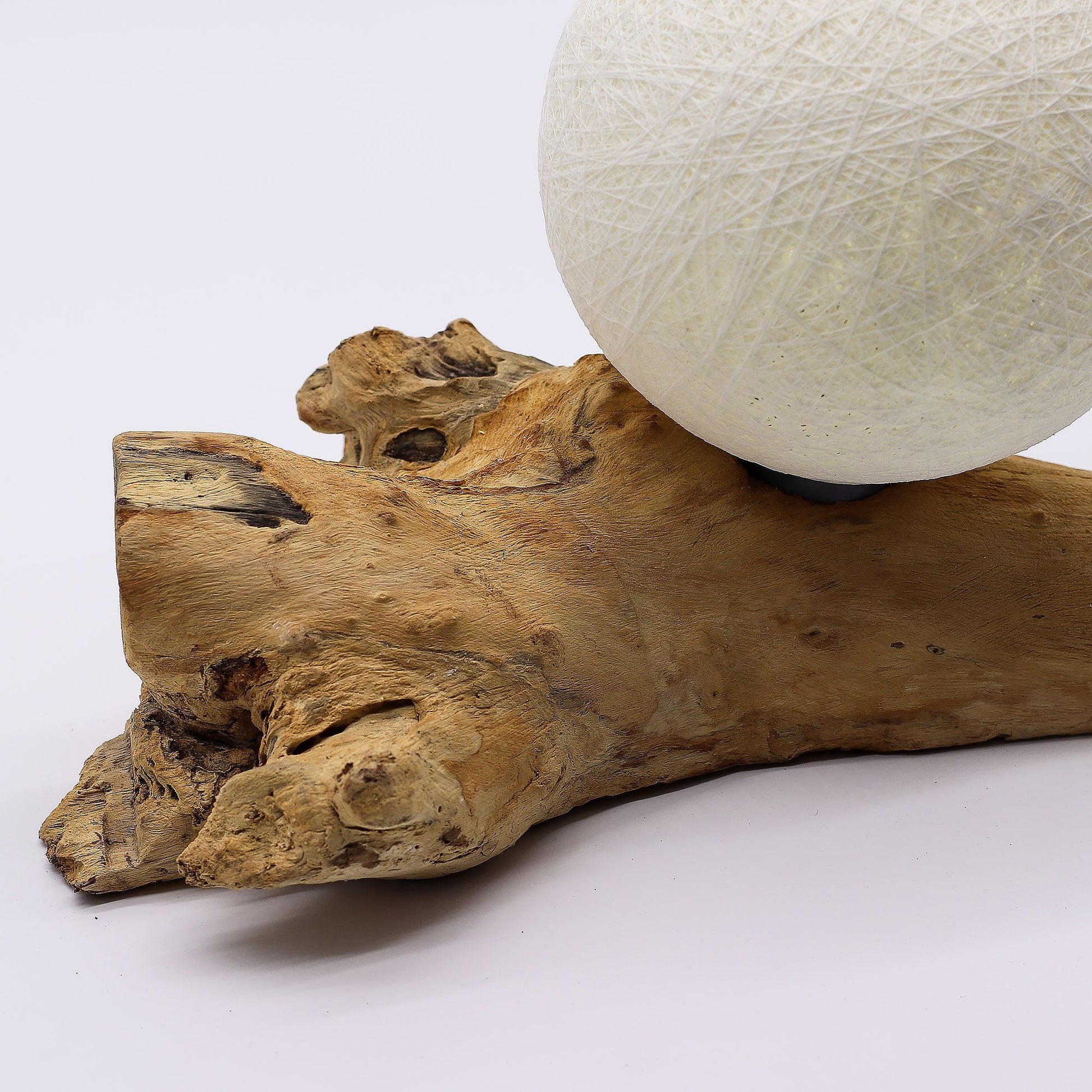 Ivory cotton-wrapped Luna sphere glowing like a full moon atop twisted driftwood base