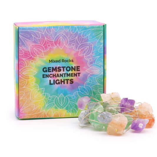 Mixed gemstone fairy lights glowing in glass bowl with amethyst, rose quartz, jade and clear quartz crystals sparkling on boho bedroom shelf