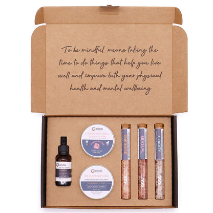 Serenity Essential Self Care Kit in elegant gift box open to reveal strawberry scrub jar, body cream, three bath salt vials, Vitamin C serum dropper bottle, fresh strawberries and lavender sprigs on marble