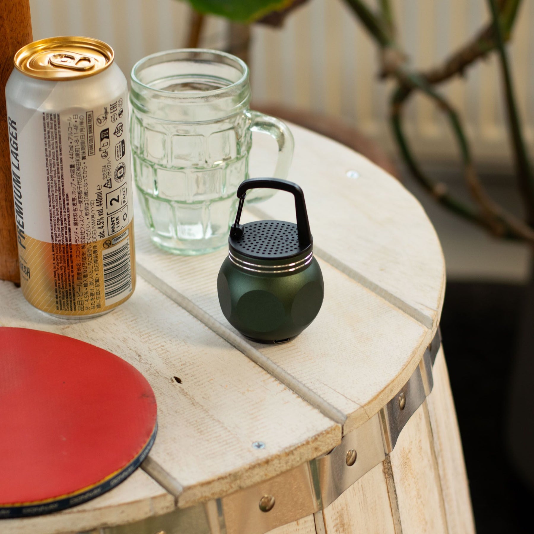 Mini speaker placed on picnic table with 5W output visible, balanced sound waves graphic overlay