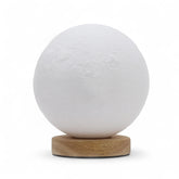 Moon New Wave USB lamp with textured honeycomb surface and crescent moon-inspired shape, warm glow on 3rd brightness setting, placed on wooden base