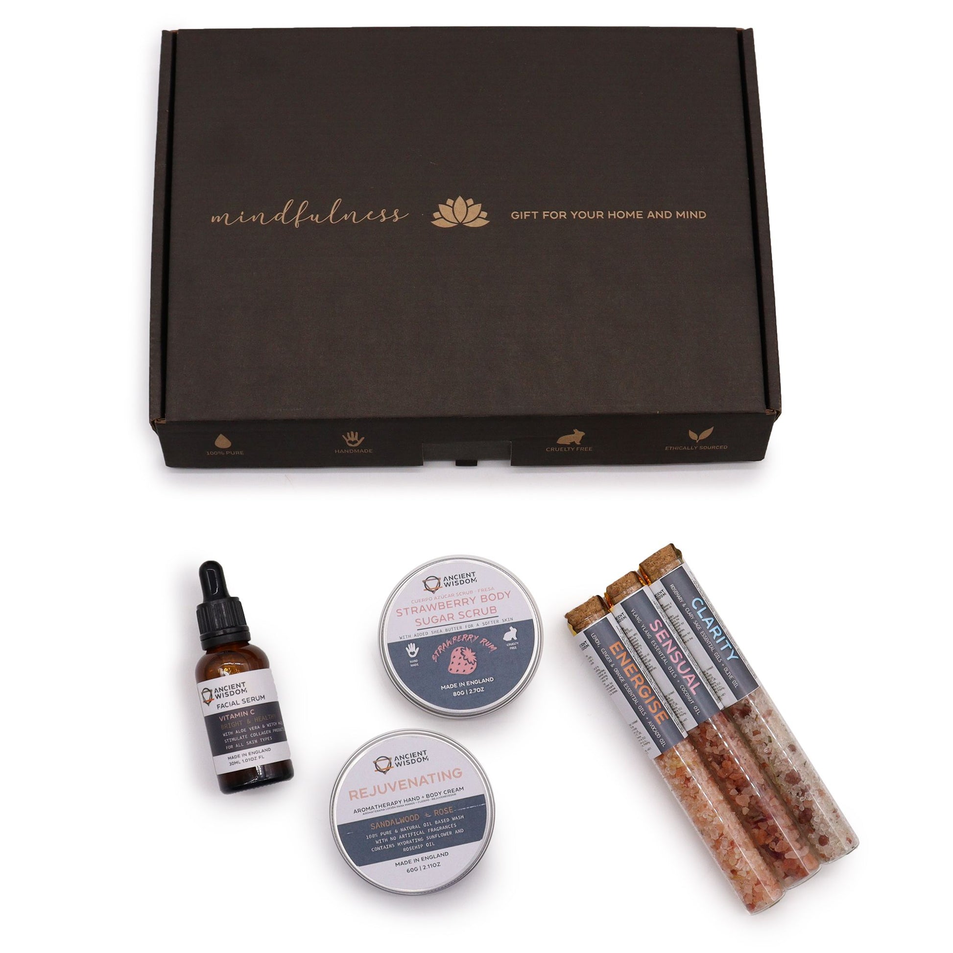Serenity Essential Self Care Kit in elegant gift box open to reveal strawberry scrub jar, body cream, three bath salt vials, Vitamin C serum dropper bottle, fresh strawberries and lavender sprigs on marble