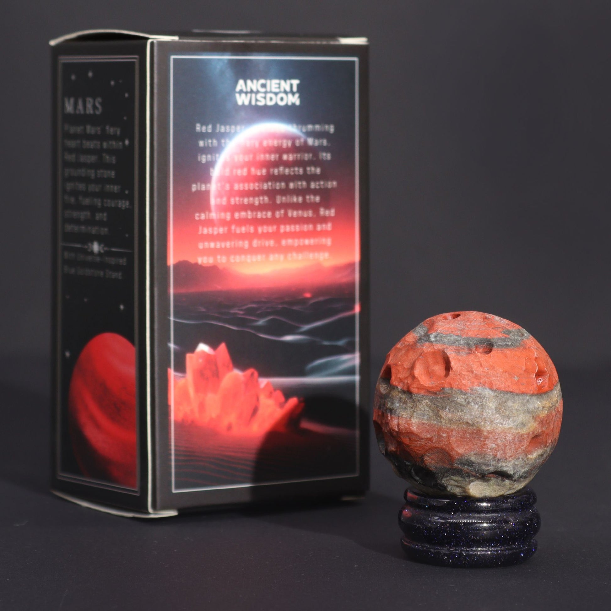 40mm deep red Jasper Mars sphere dramatically lit on sparkling goldstone ring stand against dark cosmic background with fiery glow