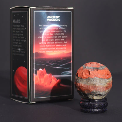 40mm deep red Jasper Mars sphere dramatically lit on sparkling goldstone ring stand against dark cosmic background with fiery glow