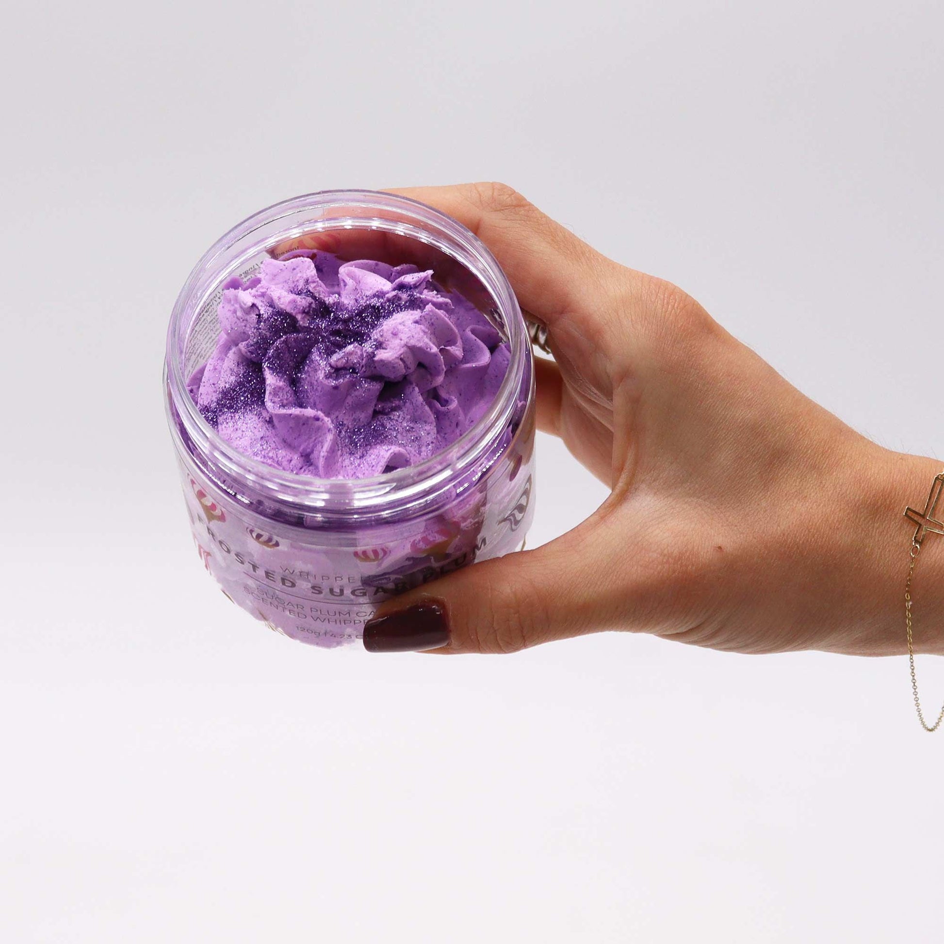 Hand holding a jar of purple bath salt