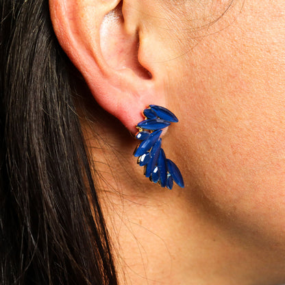 Close-up of a person wearing Royal blue vintage glass angel wing earrings