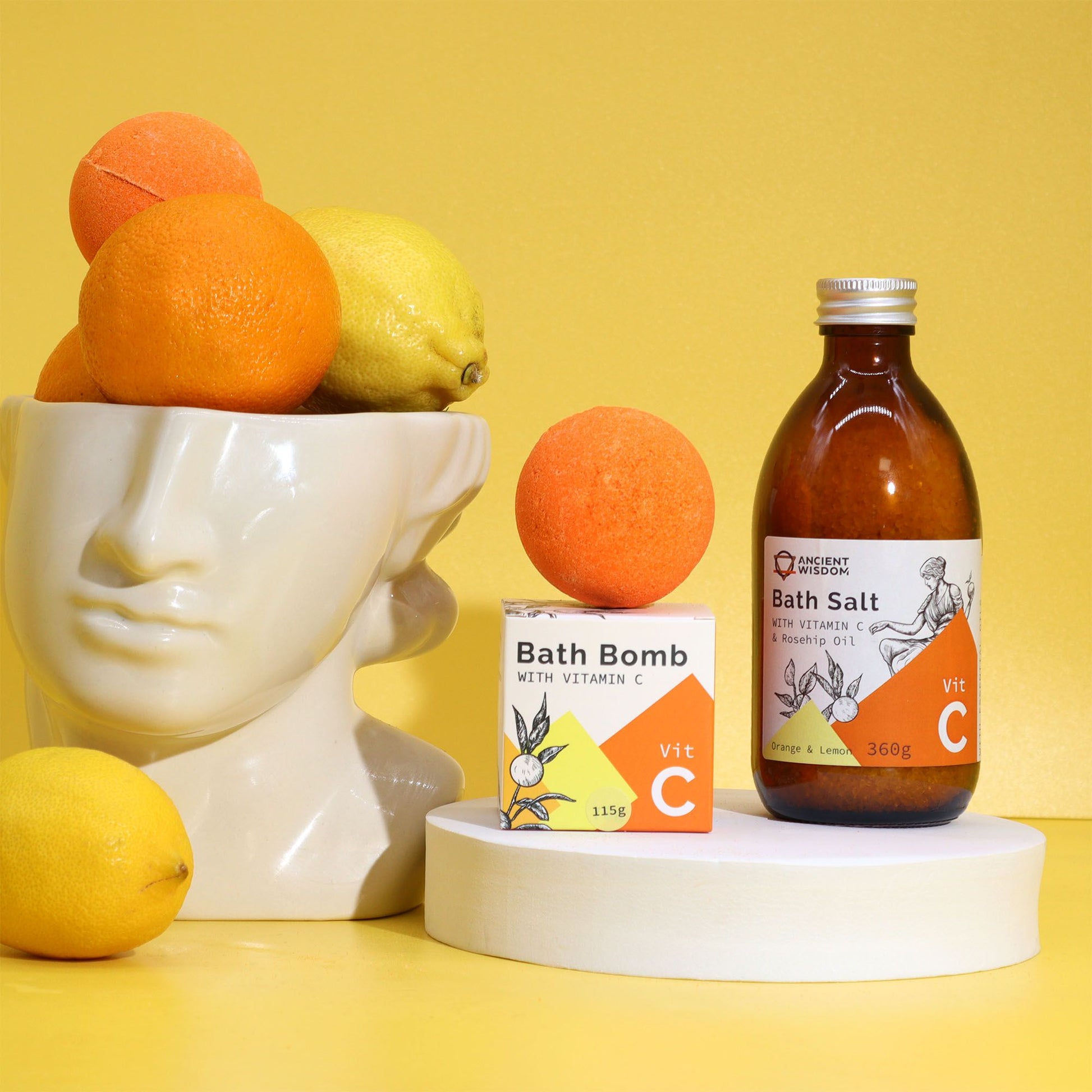 Bath salt bottle and bath bomb with vitamin C on a yellow background