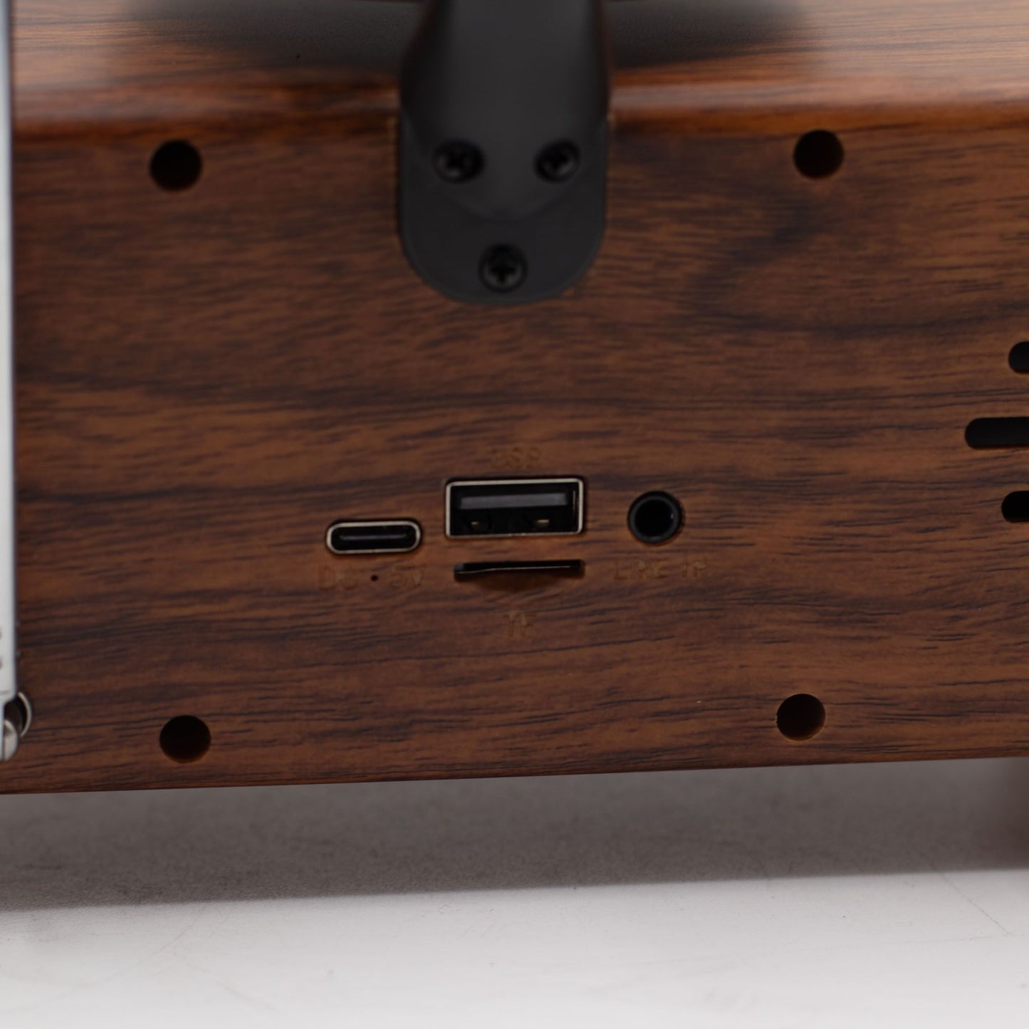 Detail of wood-effect cabinet, brass-style accents and input ports (USB, TF card, AUX)