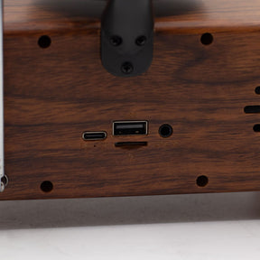 Detail of wood-effect cabinet, brass-style accents and input ports (USB, TF card, AUX)