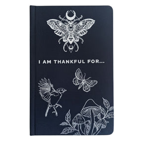 Black hardback gratitude journal with shimmering silver moon, stars & botanicals