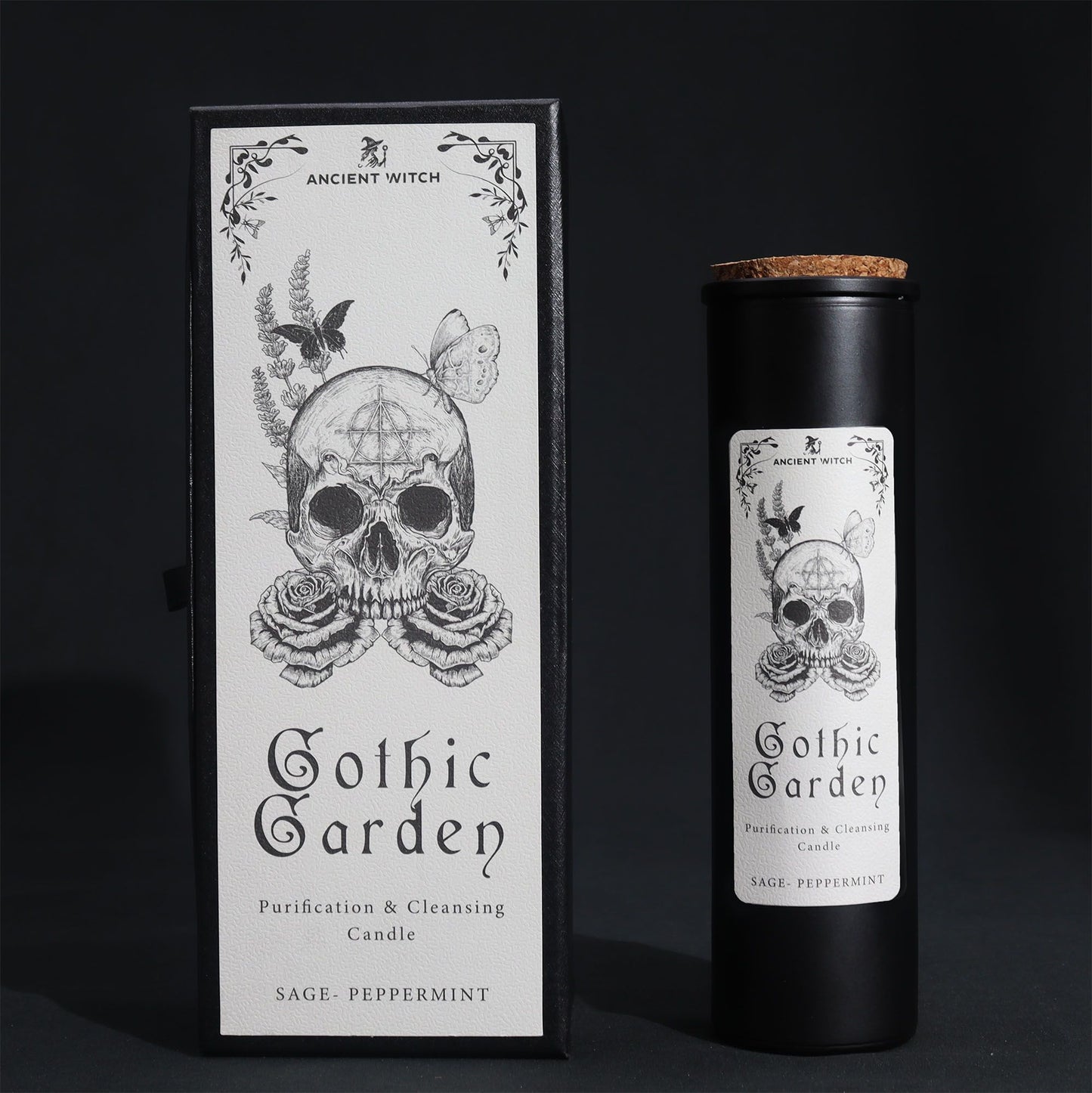 Black glass Gothic Garden candle burning with green flame, skull & roses label, surrounded by fresh sage nand peppermint leaves