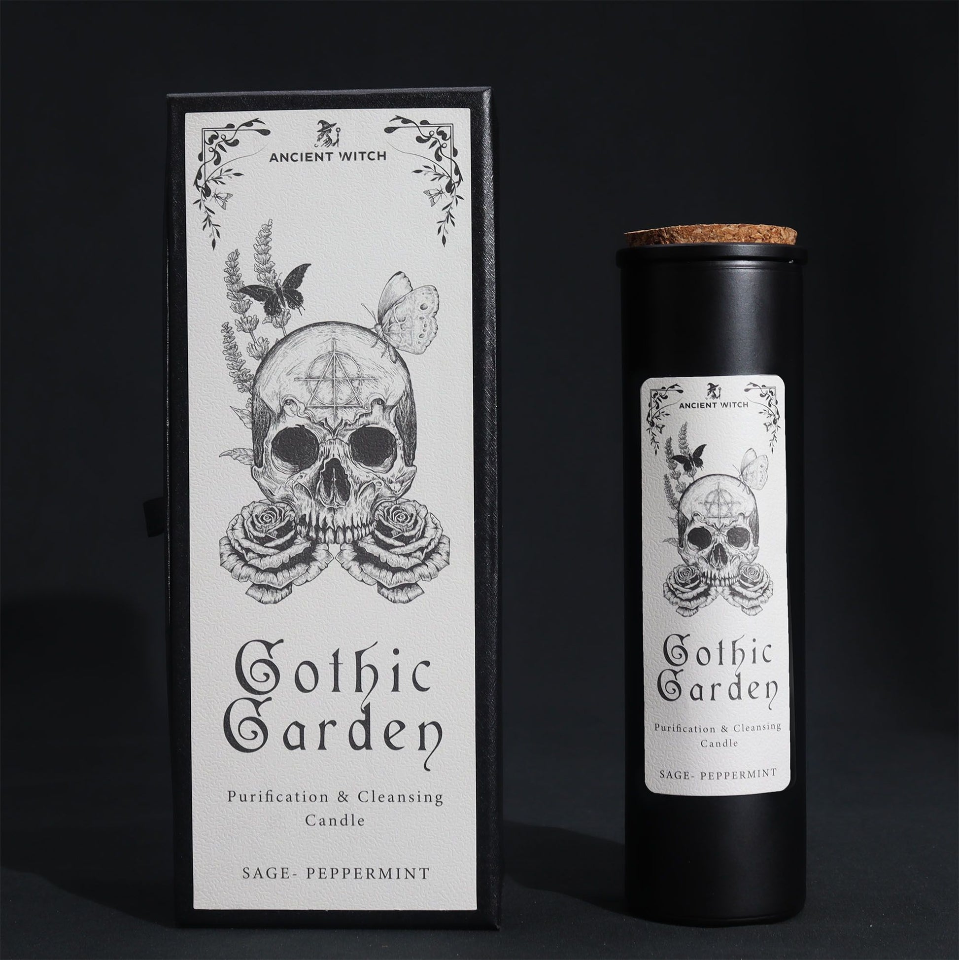 Black glass Gothic Garden candle burning with green flame, skull & roses label, surrounded by fresh sage nand peppermint leaves