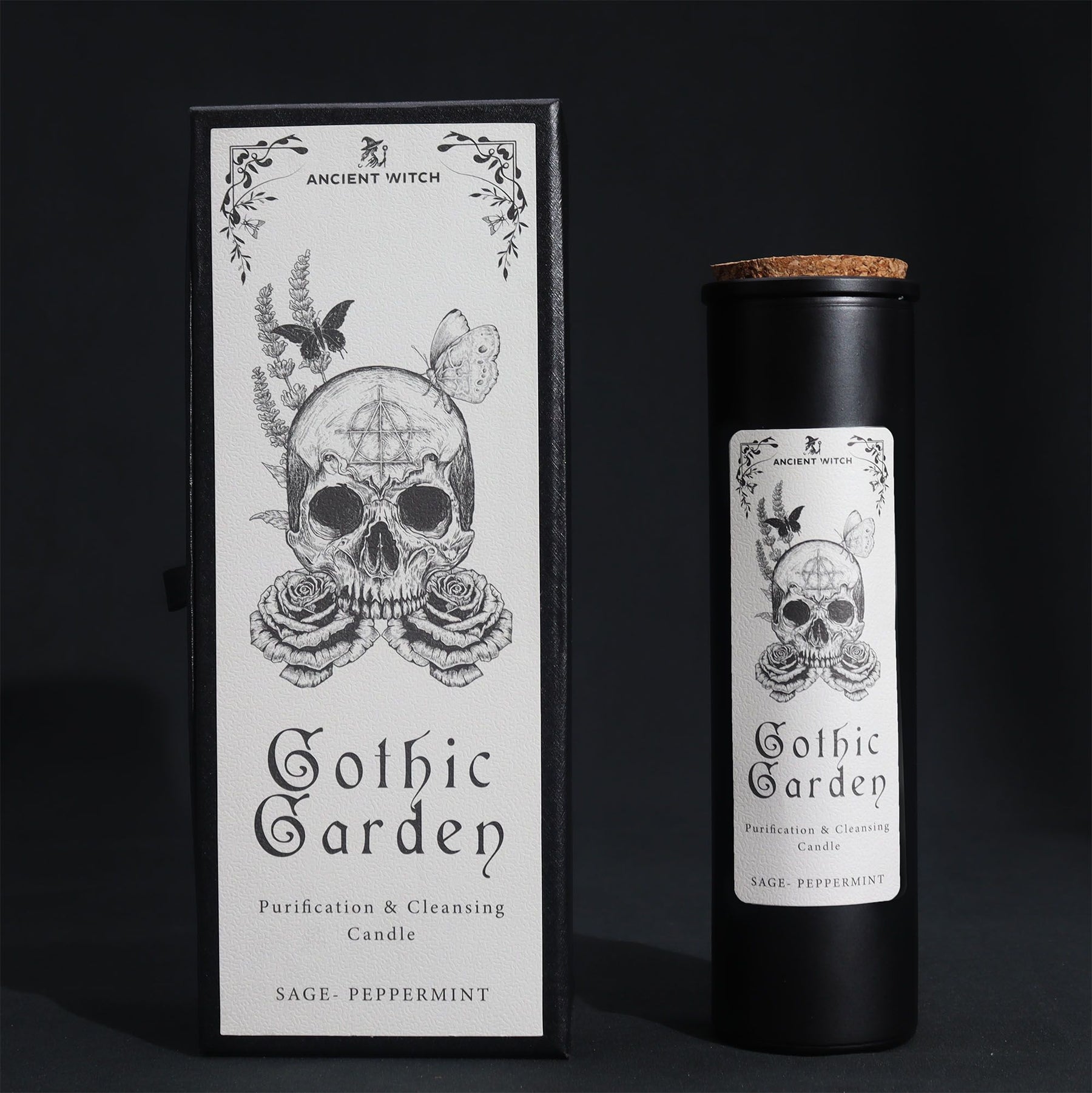 Black glass Gothic Garden candle burning with green flame, skull & roses label, surrounded by fresh sage nand peppermint leaves