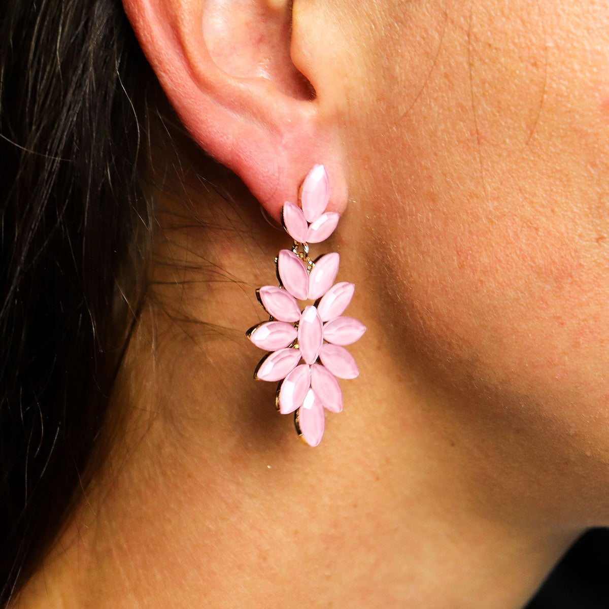 Close-up of a person wearing pink floral earrings.