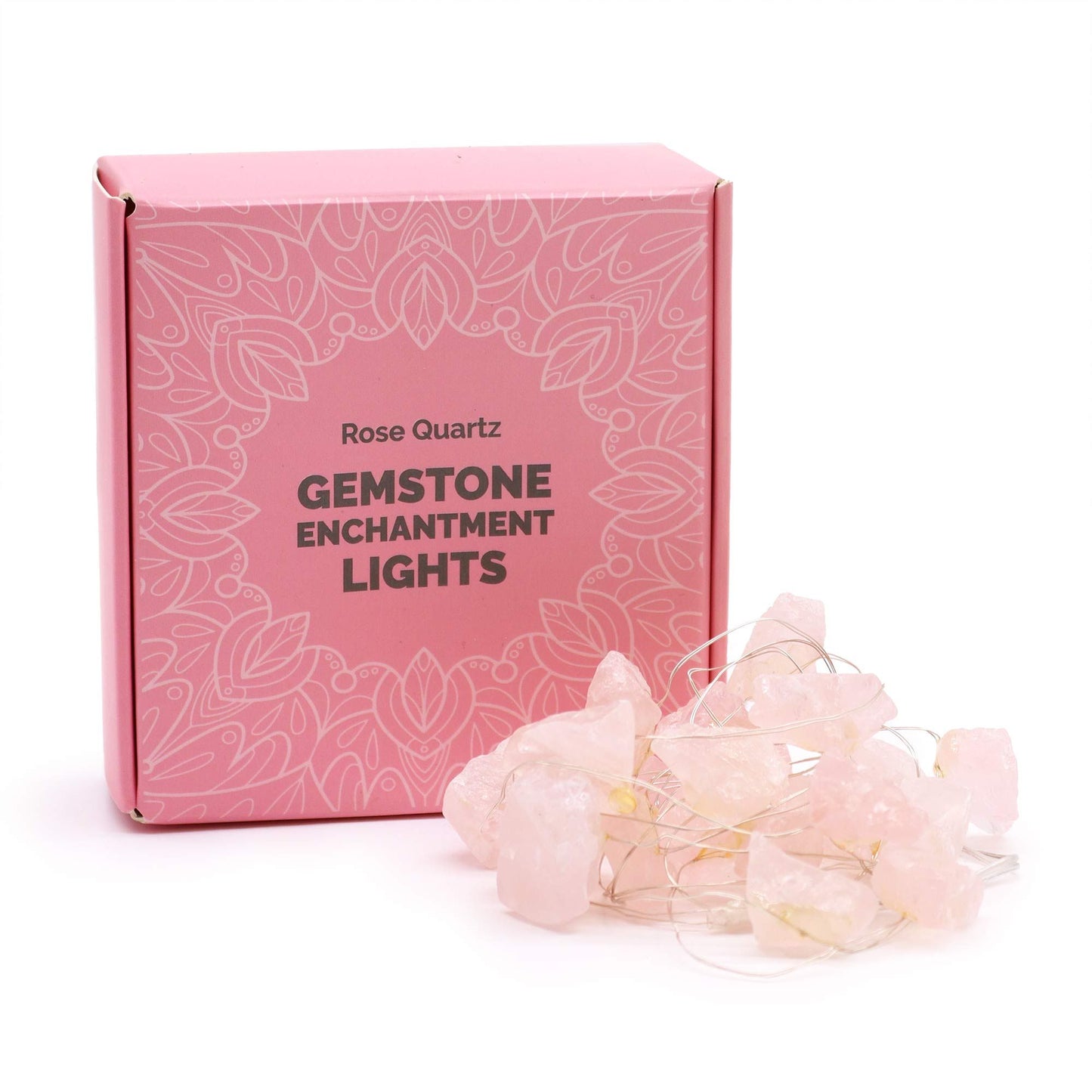 Rose quartz crystal fairy lights glowing soft pink in glass vase on bedroom dresser with roses, candles and love crystals in romantic setting
