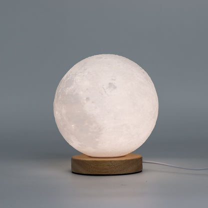 Moon New Wave USB lamp with textured honeycomb surface and crescent moon-inspired shape, warm glow on 3rd brightness setting, placed on wooden base