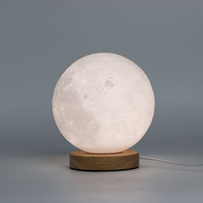 Moon New Wave USB lamp with textured honeycomb surface and crescent moon-inspired shape, warm glow on 3rd brightness setting, placed on wooden base