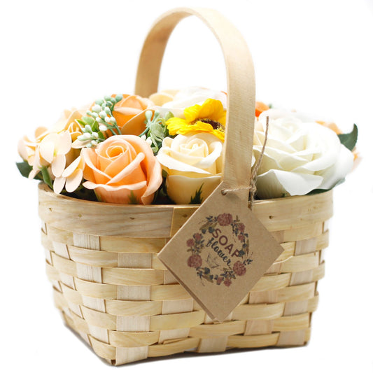 Large orange soap flower bouquet with lifelike roses and blooms beautifully arranged in natural wicker basket, tied with ribbon, presented as luxury bath gift on soft white background