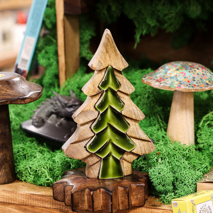 Wooden and ceramic tree figurine on a miniature landscape with a mushroom and other elements.