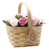 Large pink soap flower bouquet with lifelike roses and blooms beautifully arranged in natural wicker basket, tied with ribbon, presented as luxury bath gift on soft white background