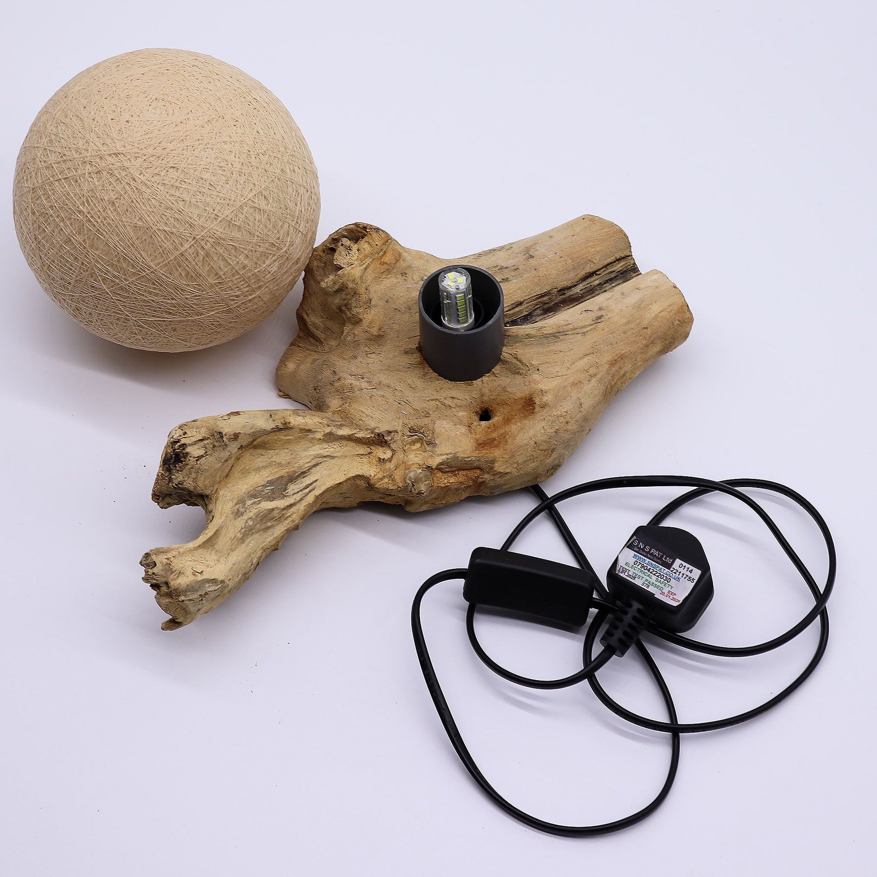 Light bulb with wooden base and ball on white background