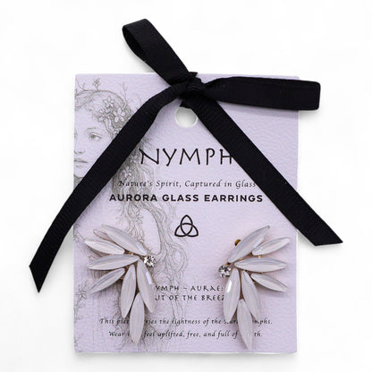 Pearl-white vintage glass fairy wing earrings catching soft dawn light, styled with white feathers and morning mist
