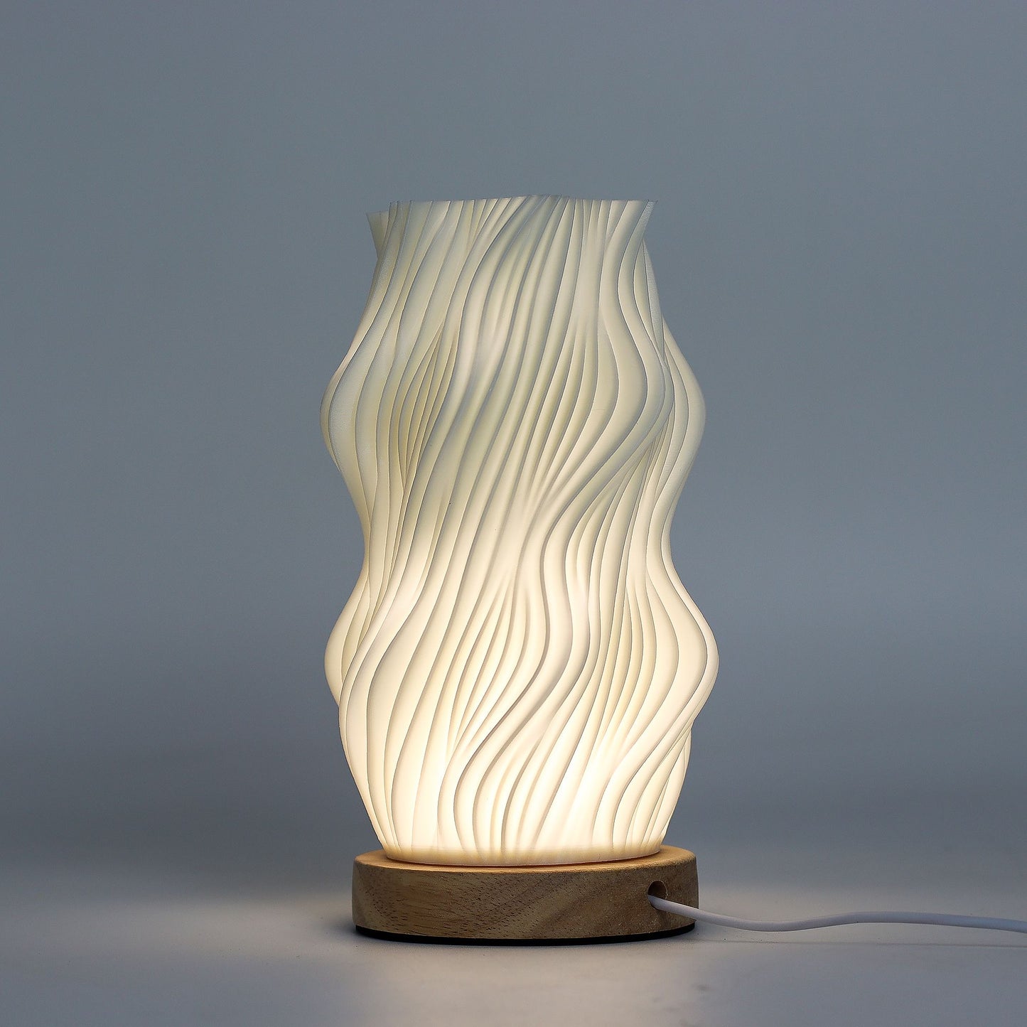 Close-up of lamp’s textured honeycomb pattern and soft diffused light, showing elegant star-like twisted shape and wooden base detail