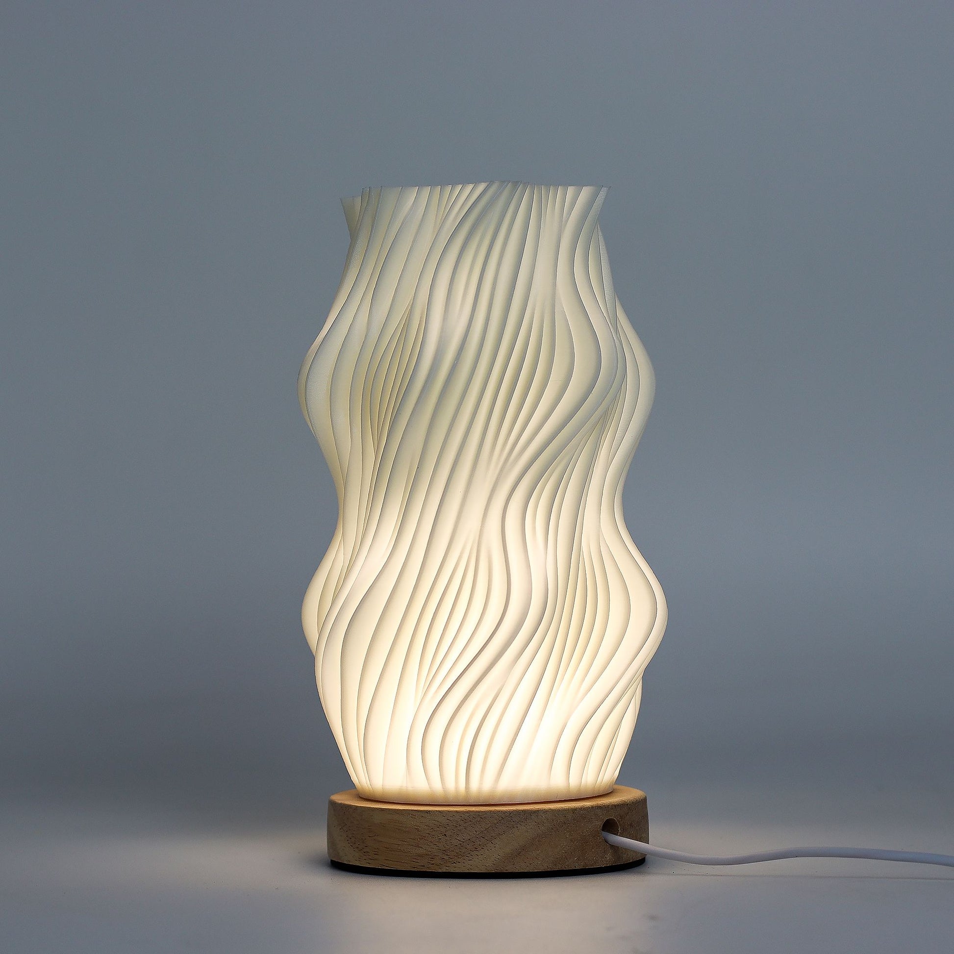 Close-up of lamp’s textured honeycomb pattern and soft diffused light, showing elegant star-like twisted shape and wooden base detail