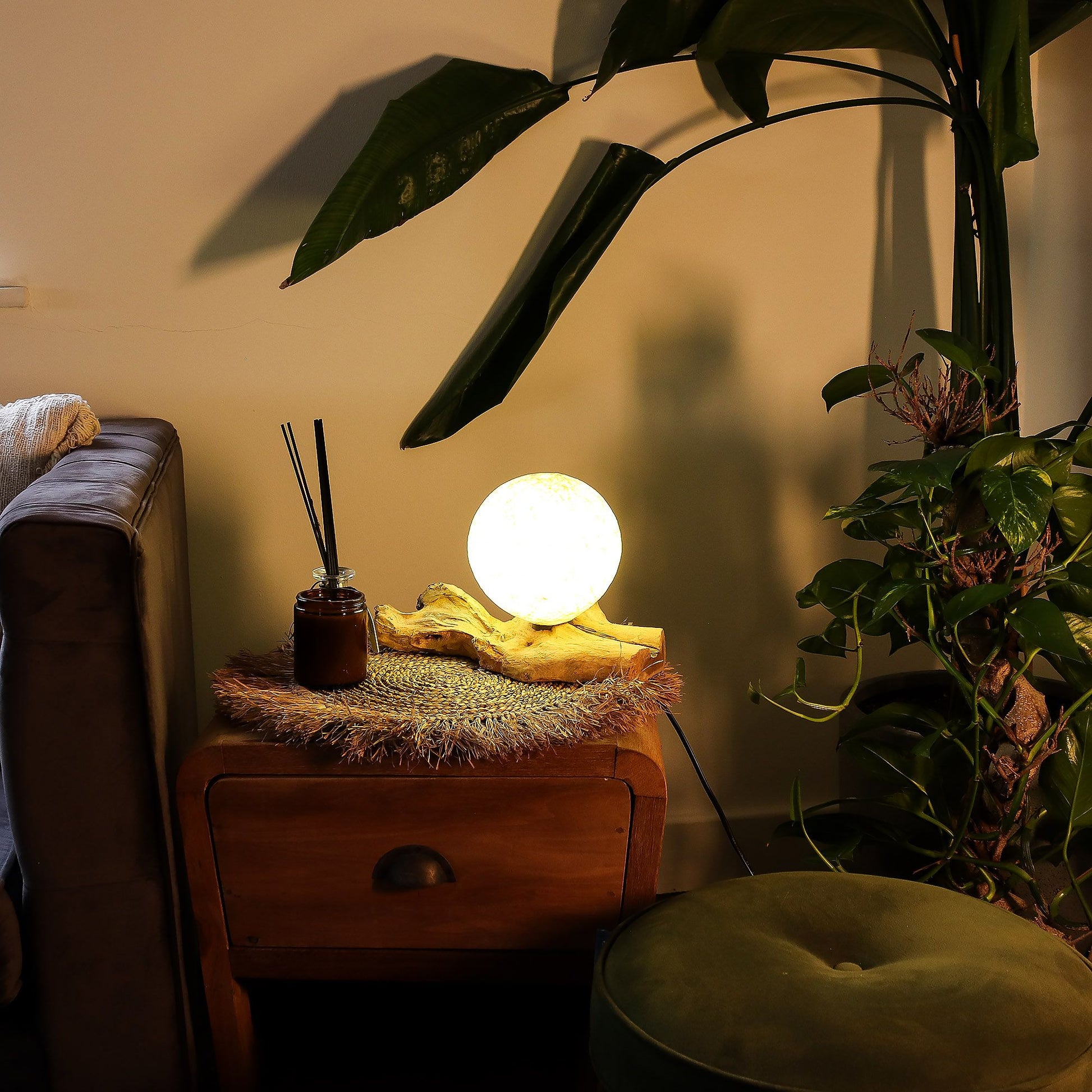 Cream cotton-wrapped sphere glowing gently atop twisted driftwood base