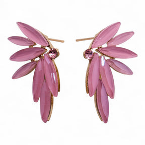 Soft pink vintage glass fairy wing earrings catching gentle light, styled beside a crystal-clear stream with rose petals floating on water