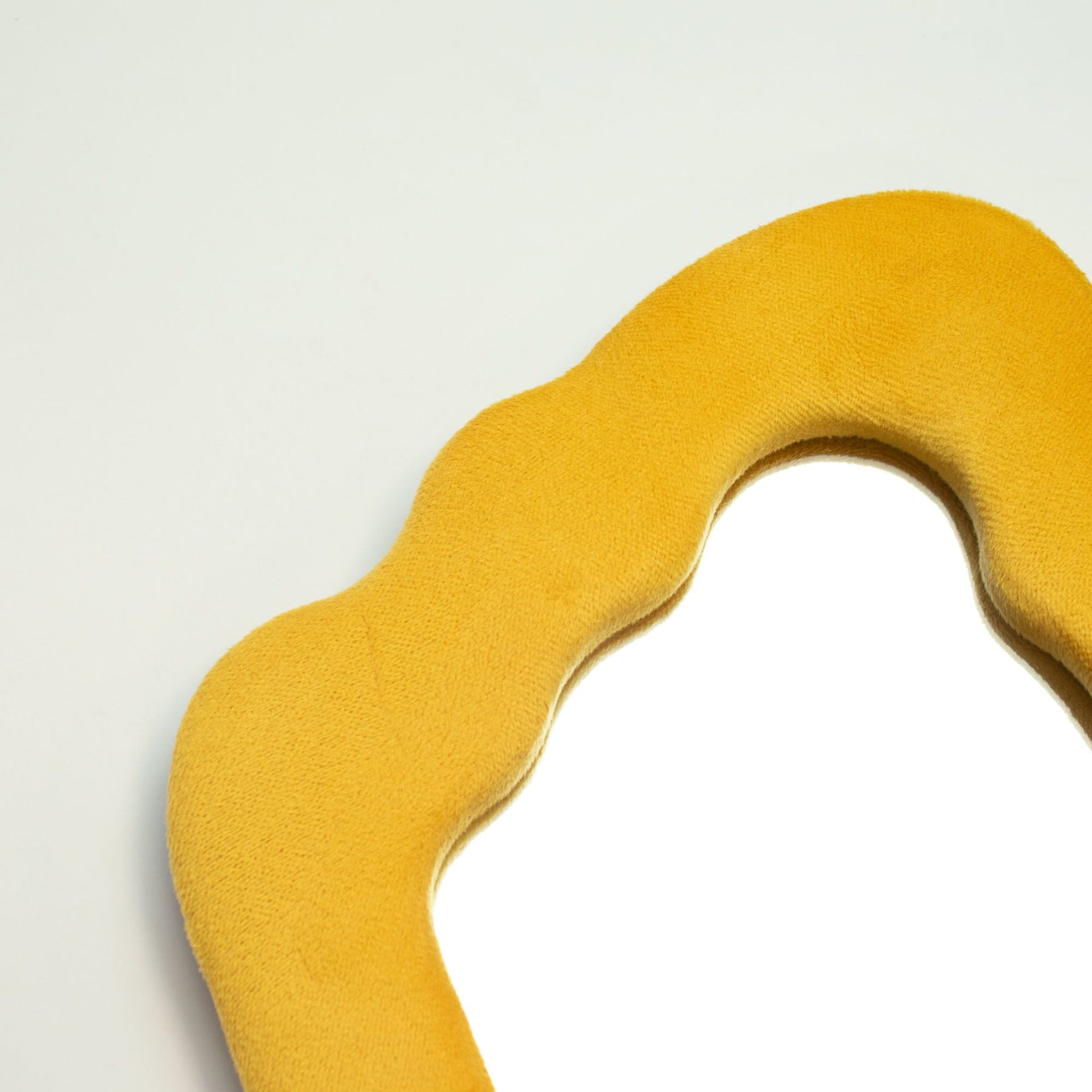 Close-up of marigold velvet texture on chunky frame, showing plush finish and playful squiggly flame edge detail